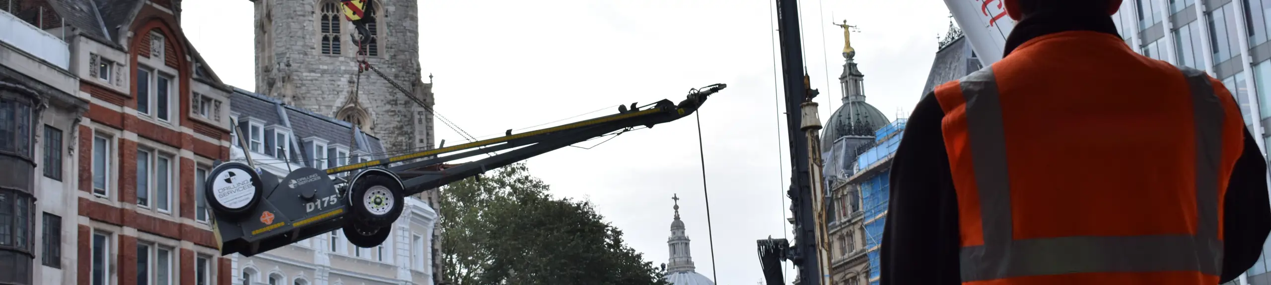 Worker watching a rig being craned into place Worker watching a rig being craned into place